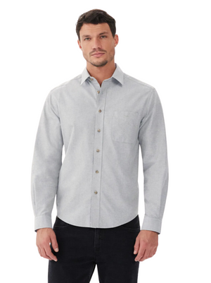 A man with short dark hair and a neutral expression wears the RM Williams Collins Shirt in light gray cotton paper poplin, featuring a chest pocket and subtle longhorn embroidery, standing against a plain white background.