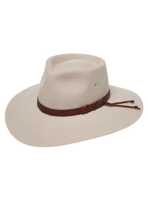 The Statesman Big Australian Fur Felt Hat, in light beige rabbit fur felt, has a wide brim and a brown leather band with a side knot, shown against a white background.
