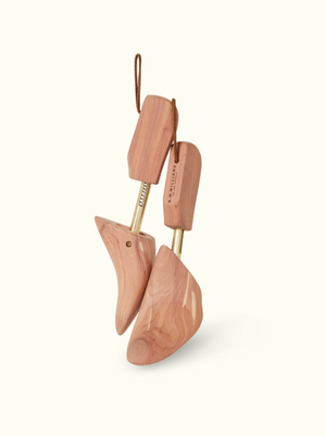 Introducing the RM Williams Red Cedar Boot Tree, a premium leather care product crafted with brass rods and leather loops. These cedar shoe trees preserve shape and absorb moisture while showcasing natural grain patterns and rich brown shades.