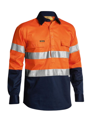 The Bisley Taped Hi Vis Closed Front Drill Shirt features long sleeves, an orange upper with reflective tape on the chest and arms, and a dark blue lower section and cuffs. Made from durable cotton drill, it includes a collar and buttoned front pockets for practicality.