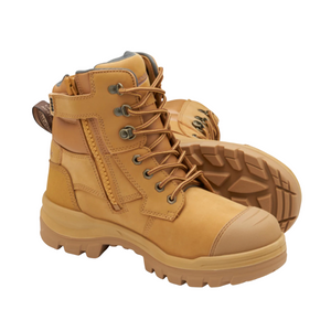 A pair of Blundstone RotoFlex 8060 Unisex Zip Sided Safety Boots in tan, featuring sturdy soles, reinforced toe caps, and lace-up fronts. They come with a water-resistant side zipper for easy access and a pull tab at the back. One boot is positioned upright while the other lies on its side to showcase the tread pattern.
