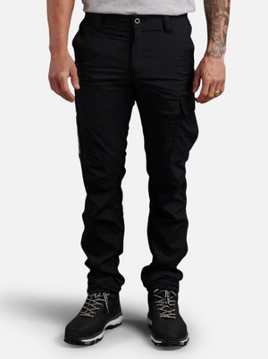 A person with a tattooed arm stands against a plain white background, wearing black King Gee Trademark Cargo Pants, black hiking boots, and a light grey T-shirt.