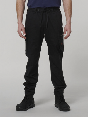 A person wearing black Hard Yakka Tough Maxx Pant cargo pants, black boots, and a navy blue shirt stands with arms relaxed by their sides against a plain light background.