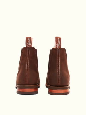 A pair of RM Williams Comfort Craftsman Boots in brown leather, shown from the back, featuring stitched pull tabs with white text and stacked leather heels.