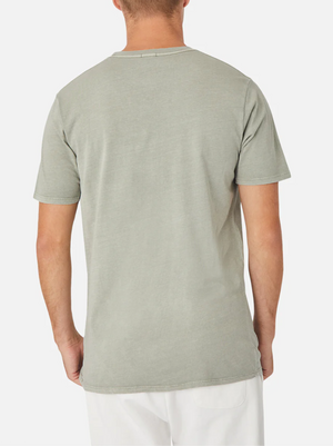 The image shows a person from the back wearing an Industrie The Basic Classic Tee in light gray and white pants. This short-sleeve T-shirt, made from 100% cotton, boasts a timeless fit with no visible logos or prints. The plain white background enhances the shirt's simplicity.