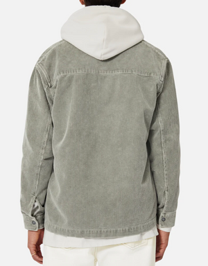 A person is seen from behind wearing the Industrie The Atmore Jacket, a stylish 100% cotton light gray corduroy piece layered over a hoodie with off-white pants, creating a relaxed, modern look.
