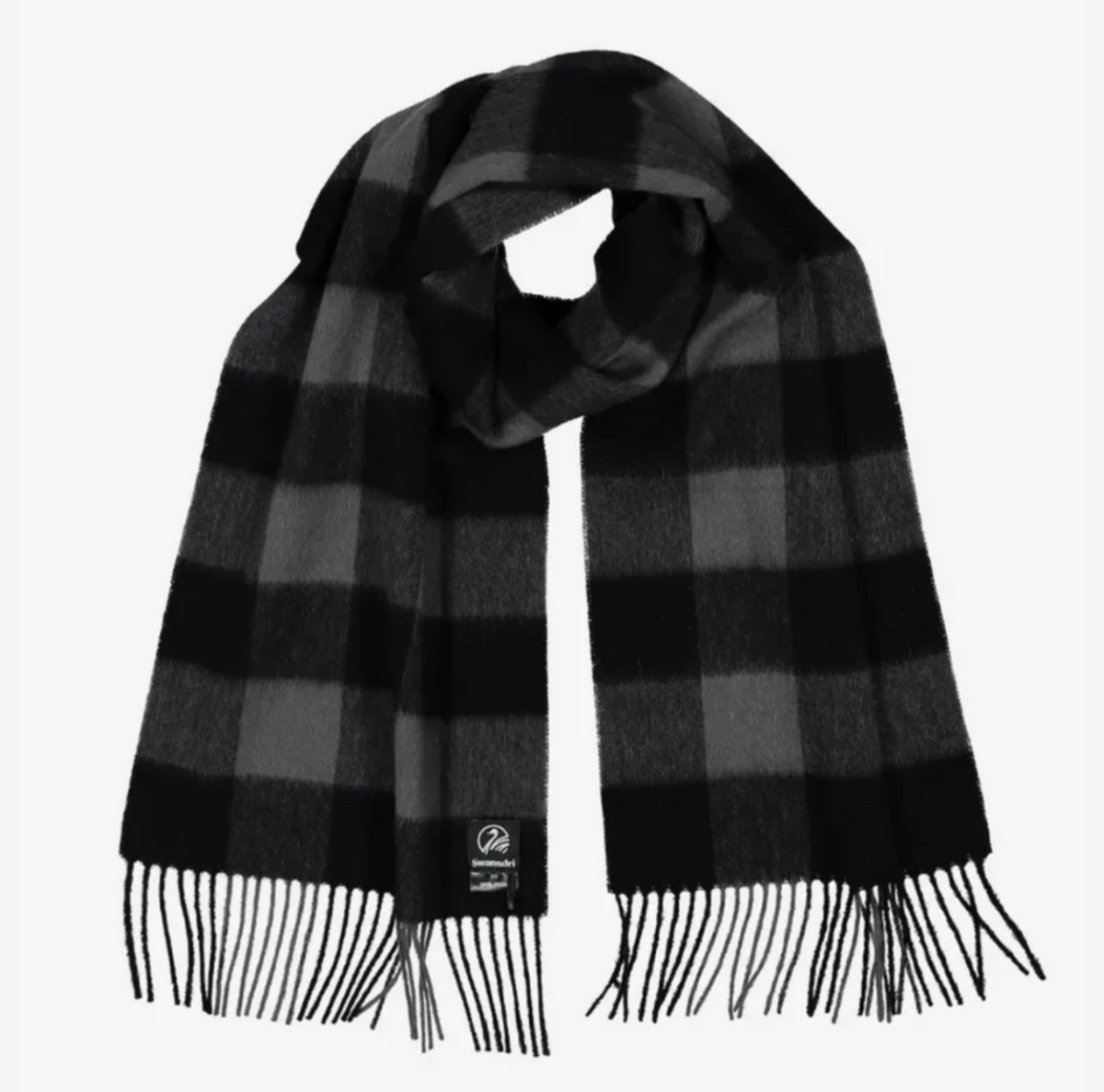 The Swanndri The Scarfie scarf is a black and gray checkered accessory made from 100% brushed wool, featuring neatly draped fringed ends and a small logo tag on one end.