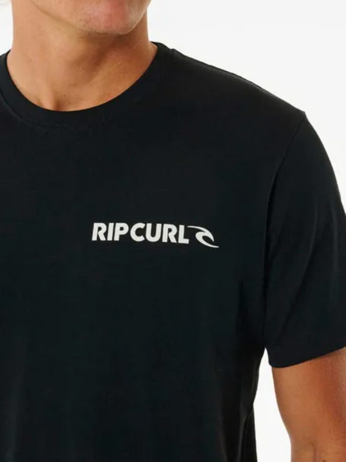 A person wears the Rip Curl Brand Icon Tee in black, showcasing the classic logo on the chest. Crafted from 100% cotton, this t-shirt is set against a plain white background, emphasizing its sleek design and quality.