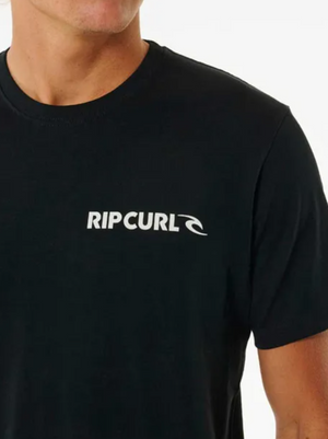 A person wears the Rip Curl Brand Icon Tee in black, showcasing the classic logo on the chest. Crafted from 100% cotton, this t-shirt is set against a plain white background, emphasizing its sleek design and quality.