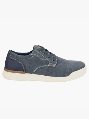 The Florsheim Kore Tour Canvas Lace Sneaker is a casual low-top shoe crafted from blue denim and breathable mesh, featuring white stitching, a white rubber sole, and a dark blue heel patch with "Florsheim" branding.