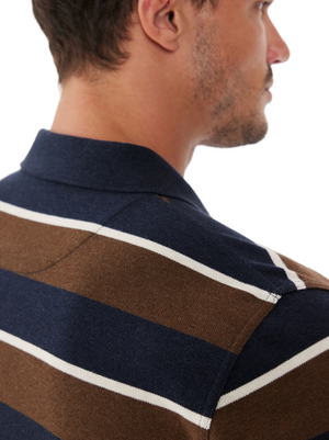 Close-up of a man seen from behind and slightly to the side wearing the RM Williams Rod Polo, a navy blue and brown striped cotton pique shirt, set against a white background.