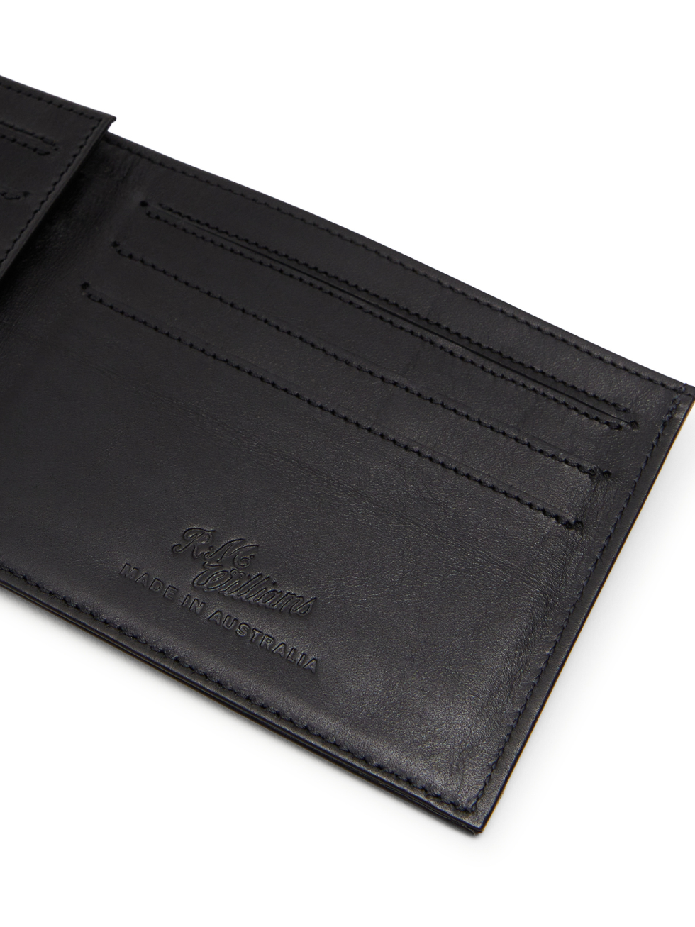Close-up of an open RM Williams Singleton Bi-fold Wallet in black leather, featuring multiple card slots. "R.M. Williams Made in Australia" is embossed near the bottom right corner, crafted from premium calf leather with RFID protection for security.