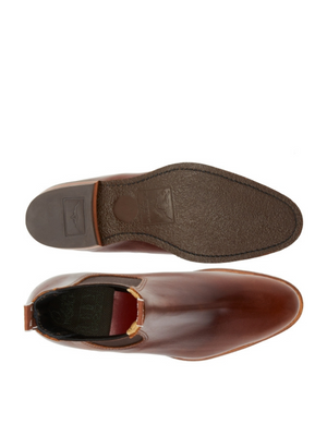 Top and bottom view of a RM Williams Lady Yearling Rubber Sole Boot. The sole is dark brown with a textured pattern and brand imprint. The top view reveals a smooth, rounded-toe design with a pull tab at the back, echoing the comfort of handmade boots.