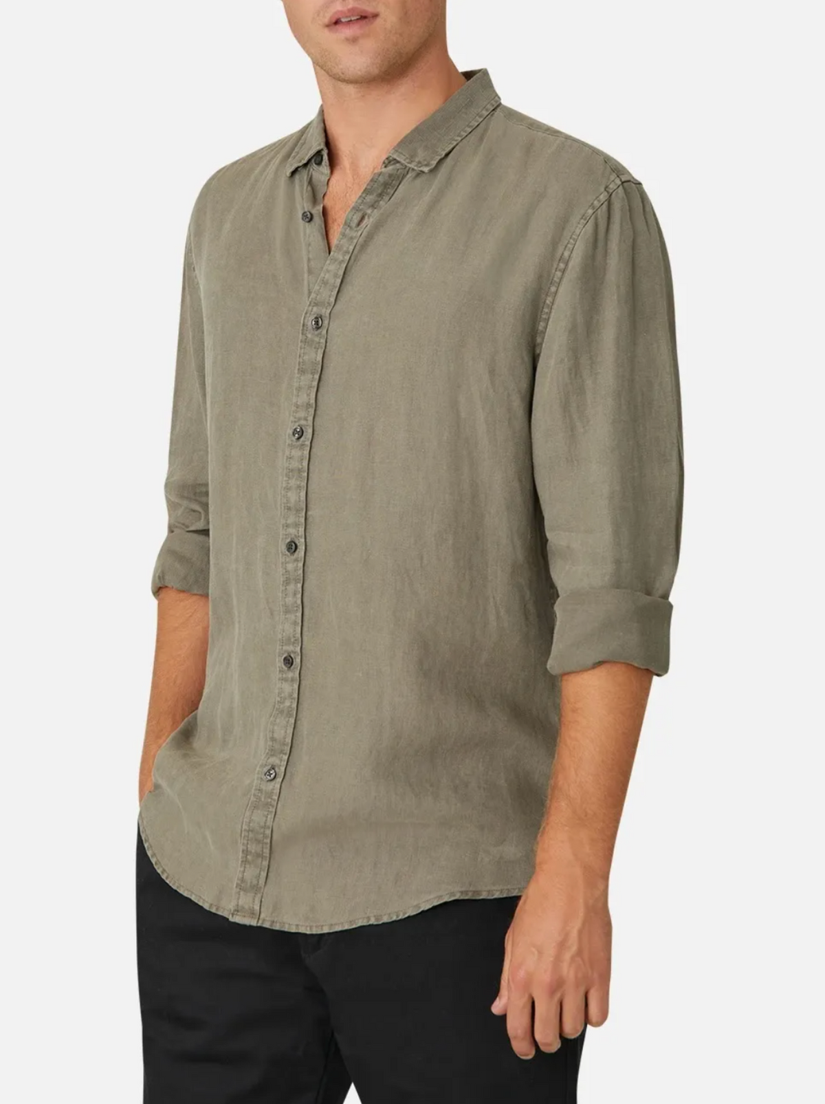 Wearing an Industrie Tennyson Linen Shirt in casual olive green with rolled-up long sleeves, paired with black pants, the person exudes a relaxed vibe against a plain white background.