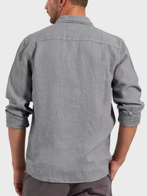A man wearing the Academy Brand Hampton Linen Shirt in light gray, shown from the back with rolled-up sleeves and one hand in his pocket, stands against a plain light background.