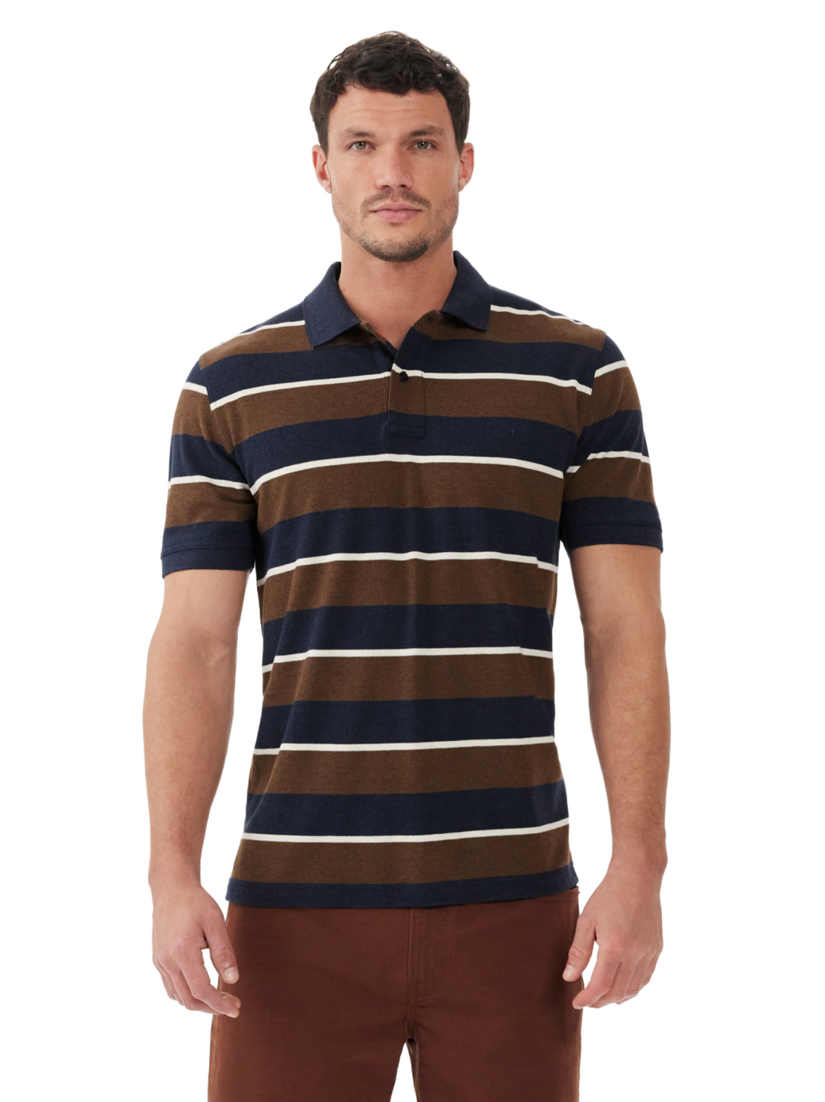 A man faces forward against a white background wearing the RM Williams Rod Polo, a breathable cotton pique short-sleeve shirt with horizontal navy blue, brown, and white stripes, paired with brown pants.