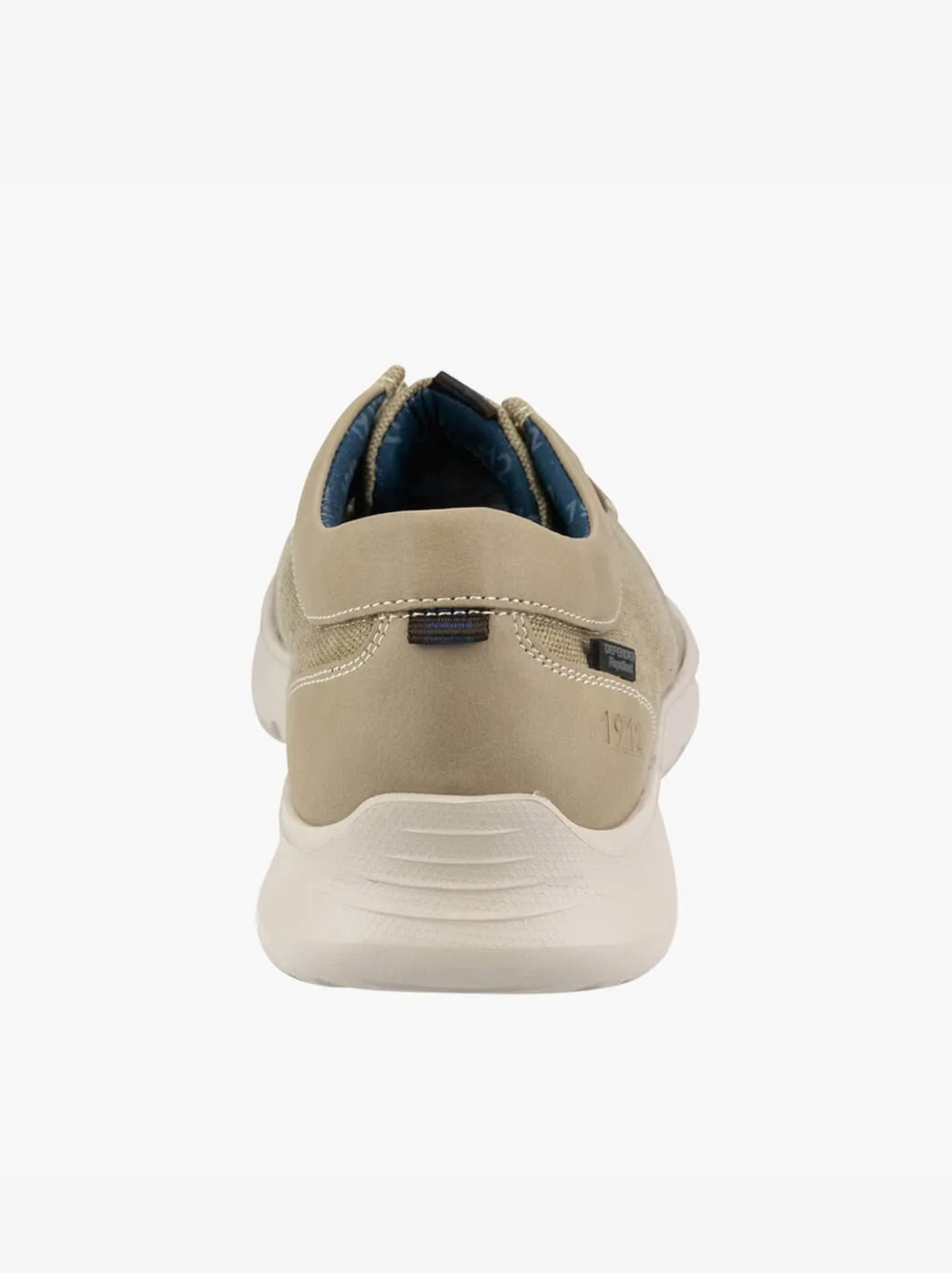 The Florsheim Bushwacker Canvas Slip On features a rear view of a beige suede sneaker with a white rubber sole. It has subtle heel stitching, dark blue inner lining, and a memory foam insole, highlighting its clean, minimalist design for comfort and casual style.