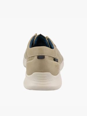 The Florsheim Bushwacker Canvas Slip On features a rear view of a beige suede sneaker with a white rubber sole. It has subtle heel stitching, dark blue inner lining, and a memory foam insole, highlighting its clean, minimalist design for comfort and casual style.
