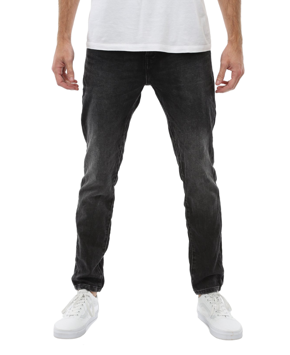A person wearing a white t-shirt, Industrie The Denim Drifter NC Pant in black faded skinny fit, and white sneakers is standing upright with their arms relaxed at their sides against a white background. The person's upper body is not visible in the image.