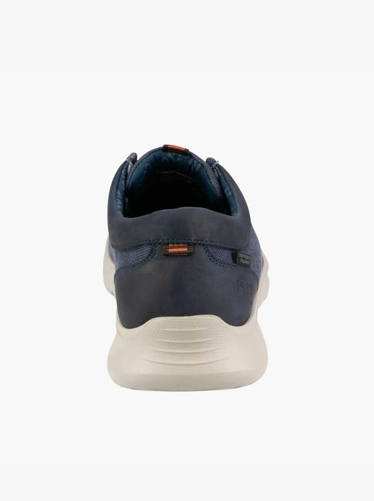 A rear view of the Florsheim Bushwacker Canvas Slip On in navy blue shows a casual sneaker with a white sole, subtle stitching, and small orange accents on the heel tab and upper back, crafted from organic cotton for comfort.