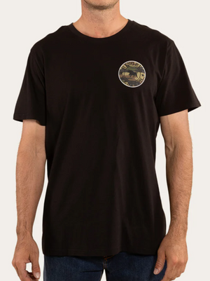 A man wears the Ringers Western Signature Bull Loose Fit T-Shirt, made from 100% cotton jersey in black. It features a small round logo with a mountain and the words "RANGER" and "Yosemite National Park." Paired with blue jeans, this classic look embodies rugged charm.