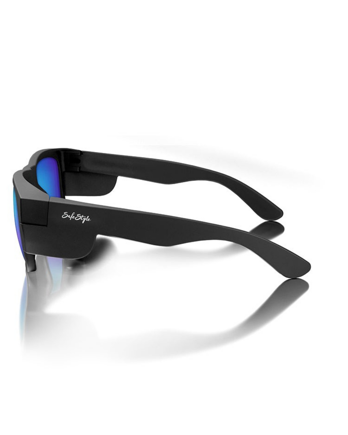 The SafeStyle Fusions Matte Black Frame Mirror features blue polarised lenses with UV protection. Seen from a rear side angle, the left arm shows a white cursive logo. The sunglasses rest on a reflective white surface.