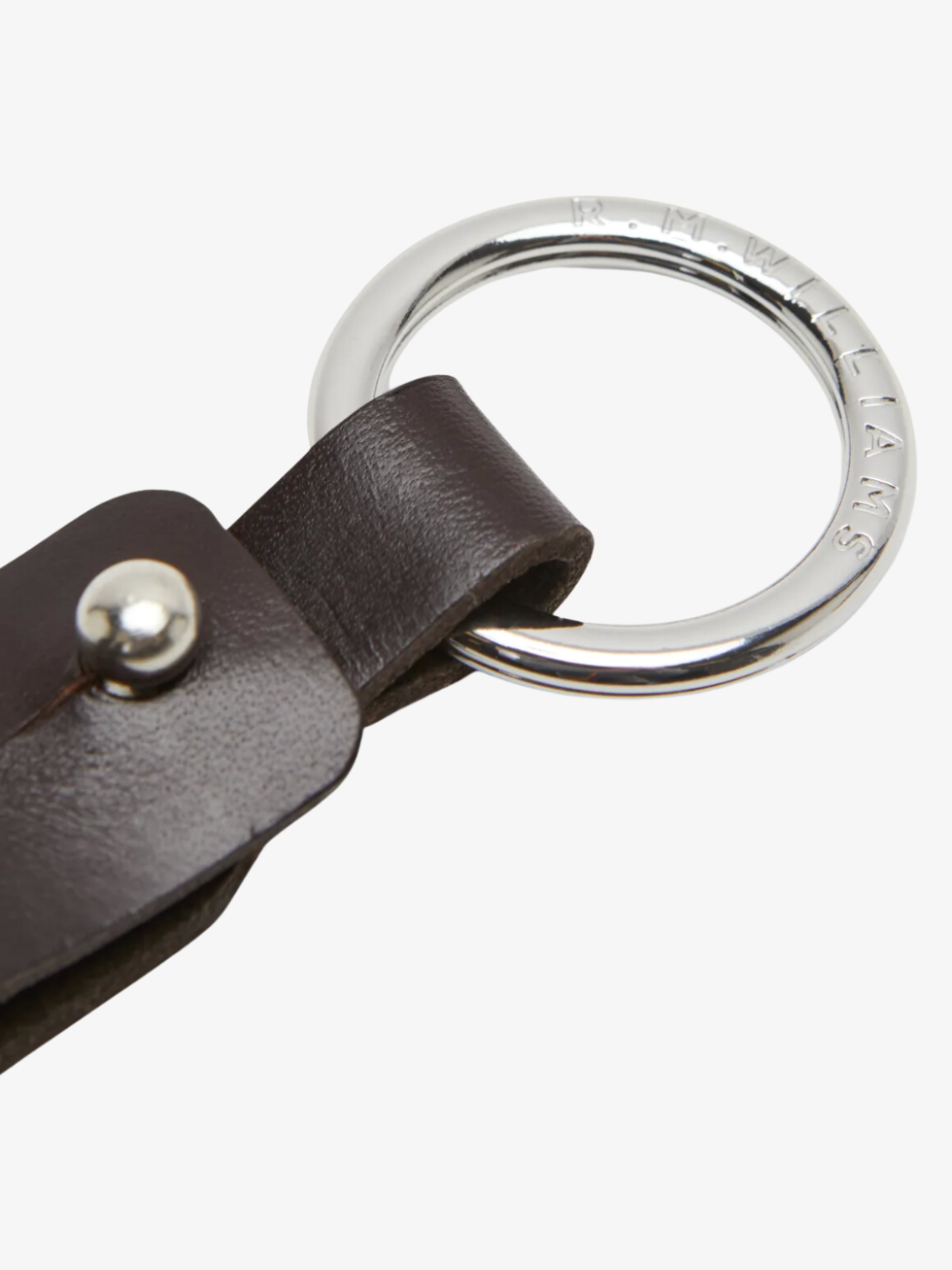 A close-up of the RM Williams Pioneer Key Fob featuring a dark brown double butt leather strap and a silver metal ring engraved with "R.M.WILLIAMS" around the edge.