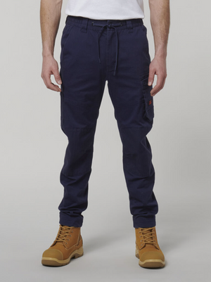 Someone is wearing Hard Yakka Tough Maxx navy cargo pants with many pockets, a white T-shirt, and tan work boots. This durable ensemble contrasts with the plain gray background and provides both style and sun protection for a long day outdoors.