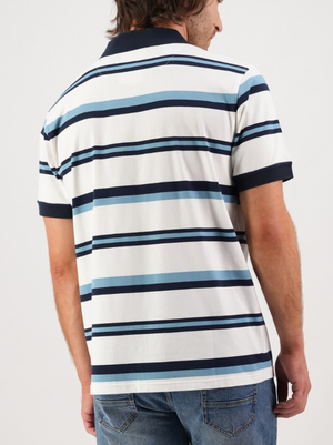 Wearing the Swanndri Winfred Stripe Polo with blue, black, and white horizontal stripes, a person with shoulder-length hair pairs it with blue jeans. Seen from the back against a plain background, the embroidered Swanndri logo adds subtle elegance to this comfortable and stylish look.