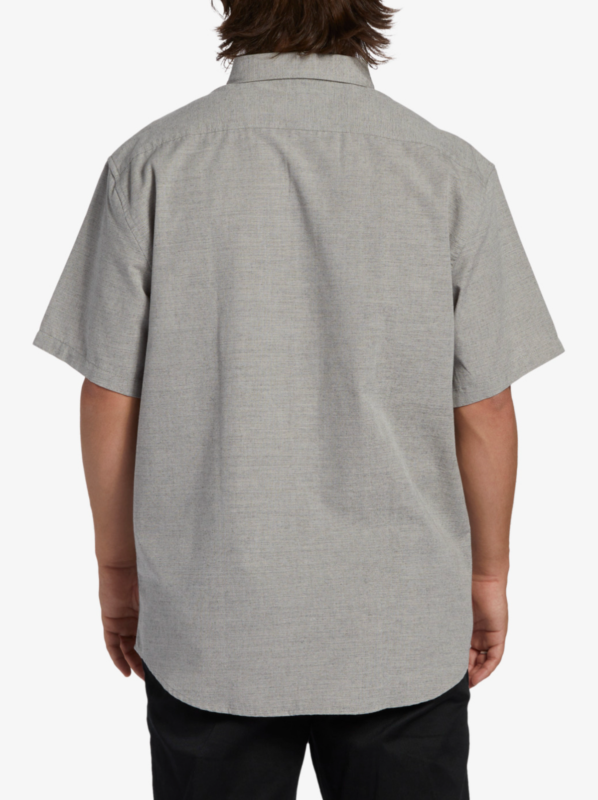 A person is seen from the back against a white background wearing a gray Billabong All Day Short Sleeve Shirt and black pants.