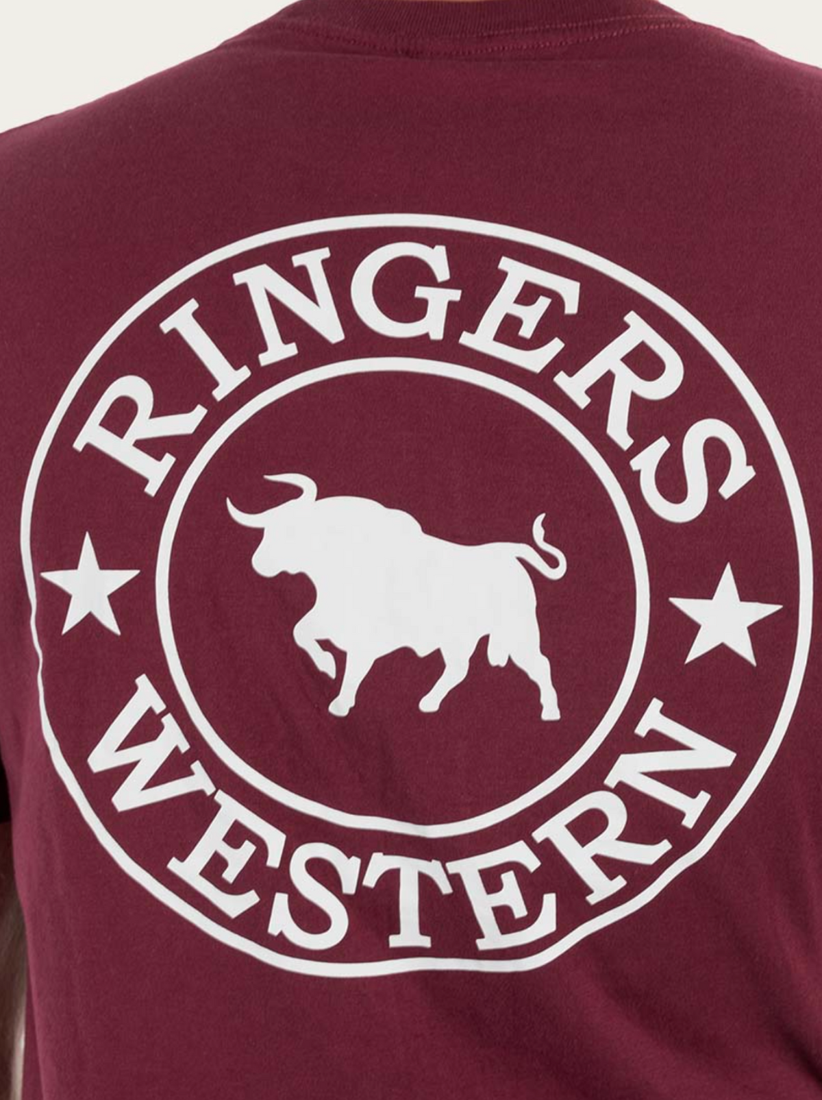 A close-up of a maroon Ringers Western Signature Bull Loose Fit T-Shirt, showcasing the white silhouette bull logo encircled by the text "Ringers Western" and flanked by two stars. Made from 100% cotton jersey for exceptional comfort.