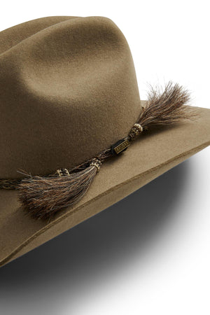 Close-up of the Akubra Rough Rider, a durable brown felt cowboy hat with a braided rope and tassel band, inspired by classic Akubra style; set against a white background.