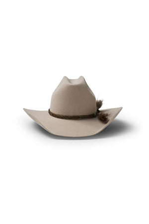 The Akubra Rough Rider is a beige cowboy hat with a wide brim and a brown braided band featuring a small feather, offering practicality and durability, shown on a white background.