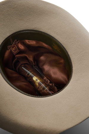A close-up view of the Akubra Rough Rider hat interior, featuring a brown satin lining, a size "57" label, and a gold "47" printed on the lining.