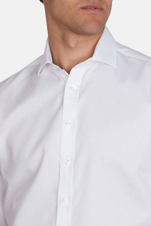 A man wears the Abelard Bedford Dobby Slim Fit Shirt in white, made from 100% cotton with a cardinal cut away collar, shown from shoulders to chin and facing slightly to the side.