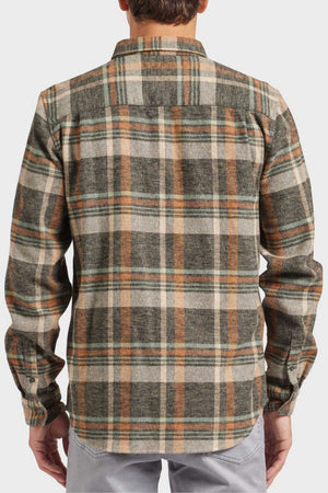 Rear view of a person in an Academy Brand Aspen Shirt, yarn-dyed twill check in green, brown, and beige, with a point collar and cuff buttons. Styled with light gray pants for a chic casual outing.