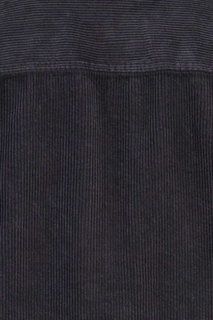 Close-up view of the dark gray, mid-weight corduroy fabric texture of the Academy Brand Lebowski Cord Overshirt, showcasing its vertical ridges and soft, tactile appearance. This 100% cotton fabric's parallel lines create a sense of depth and pattern, making it perfect for a stylish shirt.