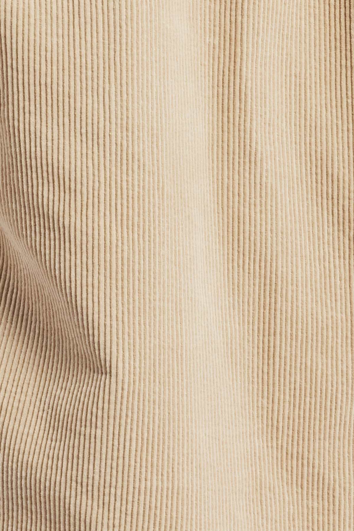 Close-up image of the Academy Brand Lebowski Cord Overshirt, showcasing its mid-weight corduroy fabric with distinctive vertical ridges and soft texture. The 100% cotton material exhibits a slight drape, forming gentle folds and shadows, making it ideal for crafting a stylish shirt.