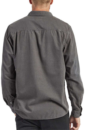 The image shows the back view of a person wearing a long-sleeved, dark gray Academy Brand Micro Cord Shirt made from 100% cotton. The shirt features a subtle vertical texture and buttoned cuffs. Paired with black pants, the overall style is casual yet polished.