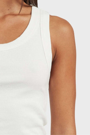 Close-up of a person wearing the Academy Women Essential Rib Tank. The image emphasizes the upper left portion of their torso, showcasing the premium, garment-washed rib texture against their natural skin tone. This essential piece, with its versatile design, is perfect for any summer wardrobe, set against a solid light gray background.