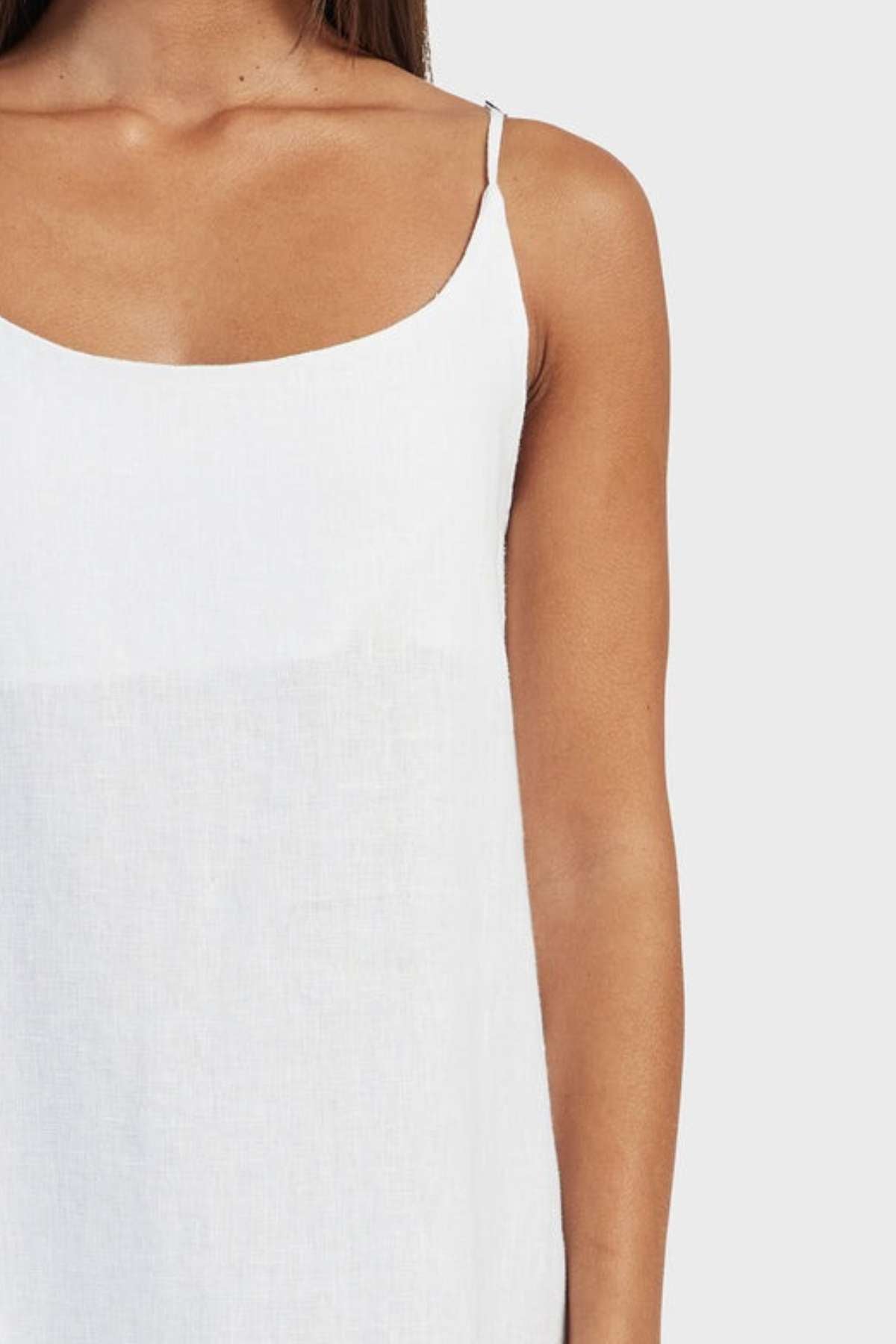 A person is wearing the Academy Women Essential Linen Slip Dress, ideal for a summer wardrobe. They are partially shown from shoulders to waist against a plain background with only the left side of their torso visible.