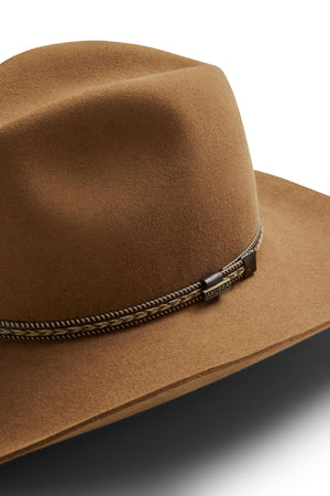 A close-up of the Akubra Dusty Dawn hat, featuring brown felt, a metal and rope band, and an "Akubra" tag. This wide-brim Western-style hat offers classic style and UPF 50+ sun protection, shown against a white background.