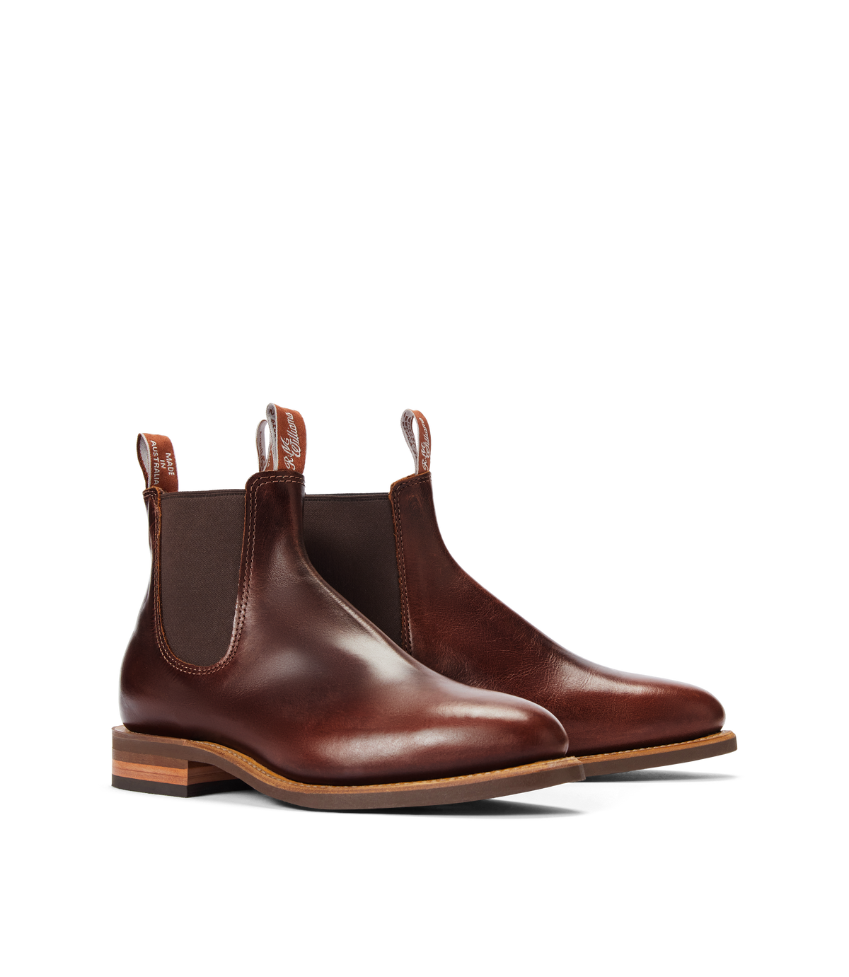 The RM Williams Moriarty Rubber Sole Boot is a pair of brown pull-up leather Chelsea boots with elastic side panels, dark brown pull tabs, and wooden stacked heels, made in Australia and shown on a white background.