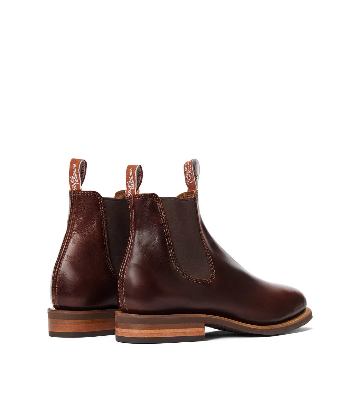 The RM Williams Moriarty Rubber Sole Boot is a brown Chelsea boot with a pull-up leather upper, elastic side panels, pull tabs, and stacked wooden heels, shown on a white background.