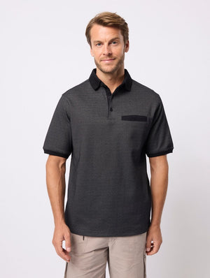 A man with light brown hair and a beard wears the Breakaway Rafael Micro Prima Polo, a men's cotton-poly blend shirt with black collar and pocket detail, standing against a plain white background.