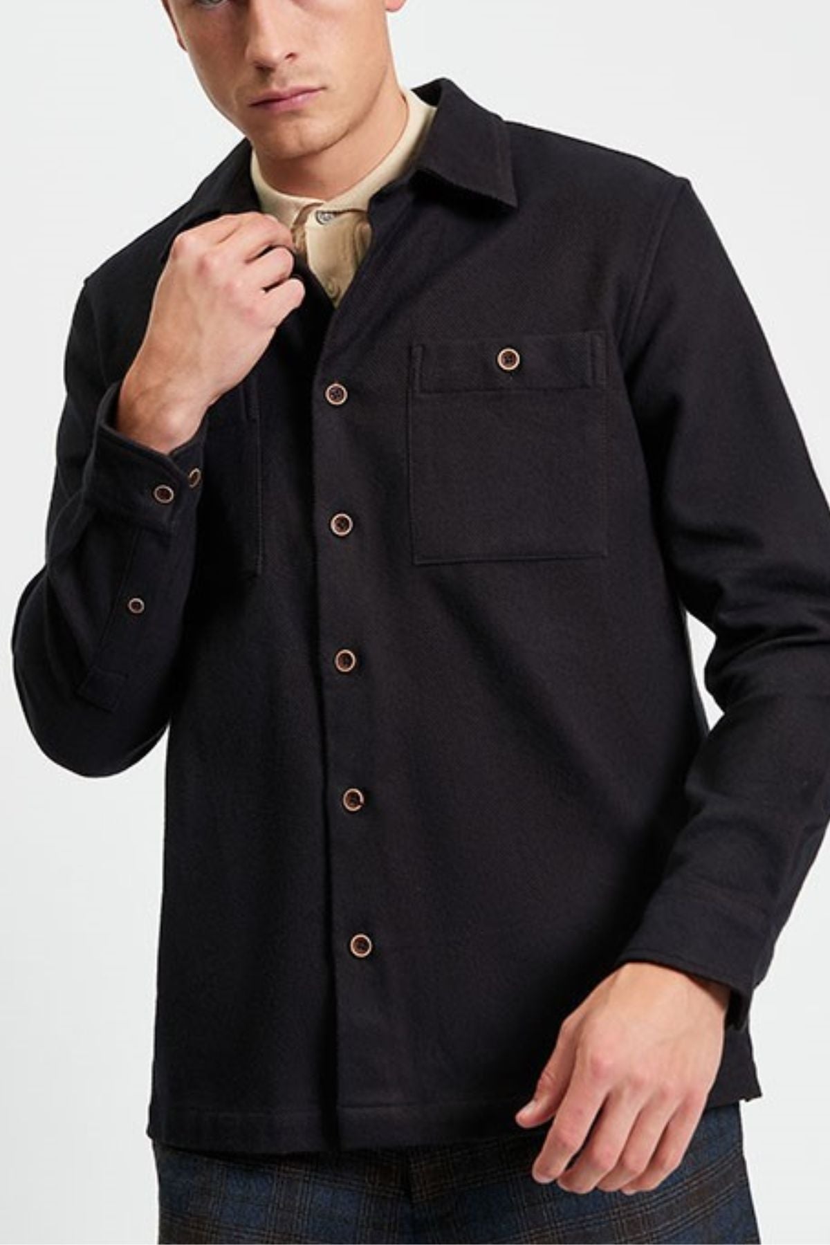 A man in a Ben Sherman Brushed Overshirt layered over a beige top stands against a plain light background, one hand near his collar, the other by his side.