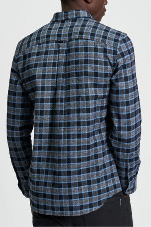 A person shown from the back wears the Ben Sherman Diffused Gingham Check Shirt, a long-sleeve button-up with a blue, black, and gray checkered pattern, standing against a plain light background.