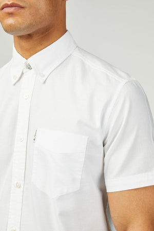 A person wearing the Ben Sherman Signature Oxford Short Sleeve Shirt, with a button-up front, collar, and chest pocket in organic cotton Oxford, shown from shoulders to mid-torso against a plain background.