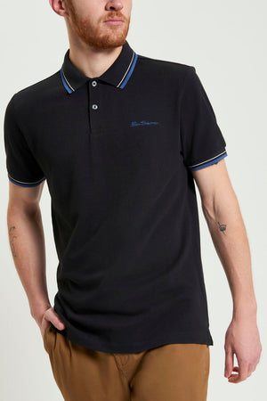 A man wearing the Ben Sherman Signature Pique Polo in black.