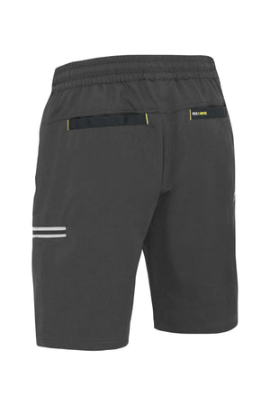 The Bisley Flex & Move 4 Way Stretch Elastic Waist Cargo Short is designed in black with side-view features, crafted from 4-way stretch fabric. It includes an elastic waistband, a small reflective stripe along the side, and discreet pockets with a 'FKN MOVE' label above one pocket for enhanced flexibility and style during every movement.